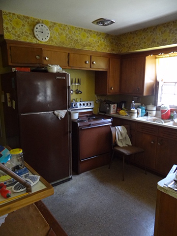 A kitchen with a yellow wallpaper